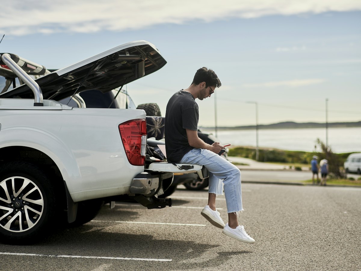 A man sitting on the back of a ute